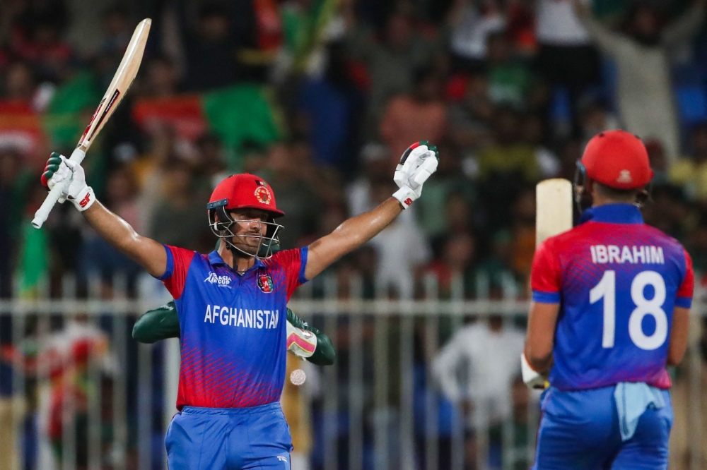 Afghanistan's Najibullah Zadran (L) celebrates after hitting a boundary to win the Asia Cup Twenty20 international cricket Group B match between Afghanistan and Bangladesh at the Sharjah Cricket Stadium in Sharjah on August 30, 2022. (Photo by Surjeet Yadav / AFP)

