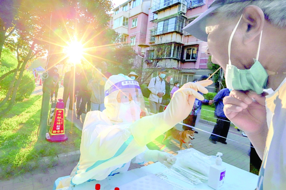 A health worker taking a swab sample from a man to be tested for the Covid-19 coronavirus in China's northern Tianjin. - AFP