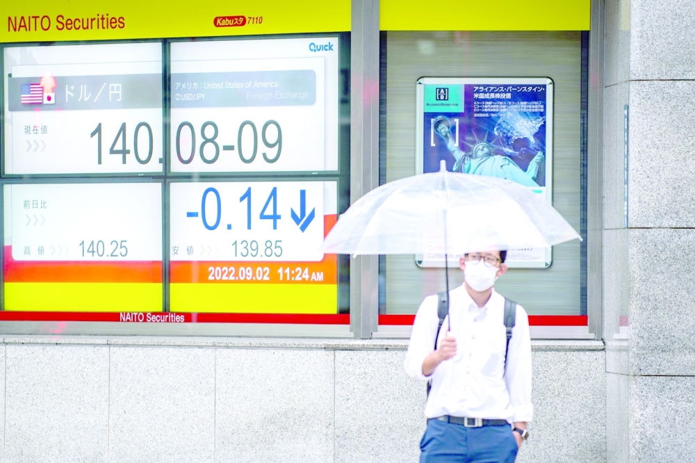 A man stands in front of an electronic quotation board displaying the rate of the Japanese yen against the US dollar in Tokyo on Friday. - AFP