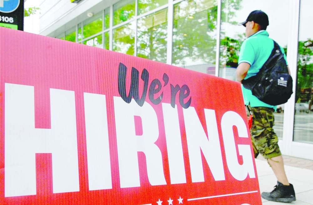 A man walks past a "now hiring" sign posted outside of a restaurant in Arlington, Virginia. - AFP