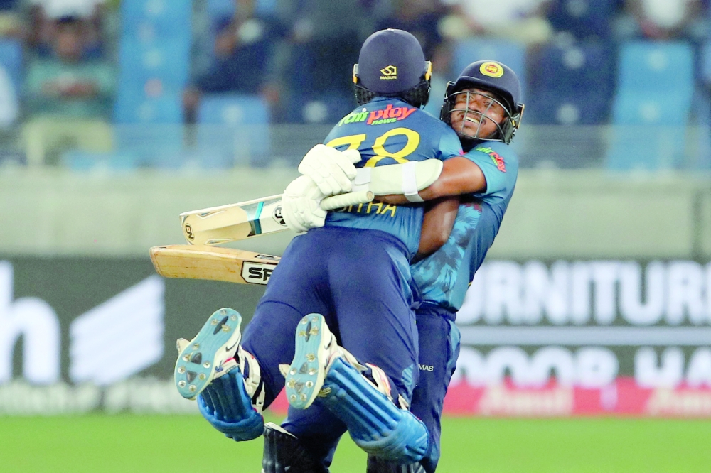 Sri Lanka's Asitha Fernando (L) and Maheesh Theekshana celebrate their win as Bangladesh's captain Shakib Al Hasan walks past them during the Asia Cup Twenty20 international cricket match between Bangladesh and Sri Lanka at the Dubai International Cricket Stadium in Dubai on September 1, 2022. (Photo by Surjeet Yadav / AFP)

