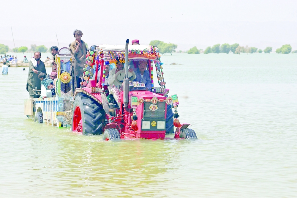 People fleeing flood-affected areas on a tractor in Sindh province. -- AFP
