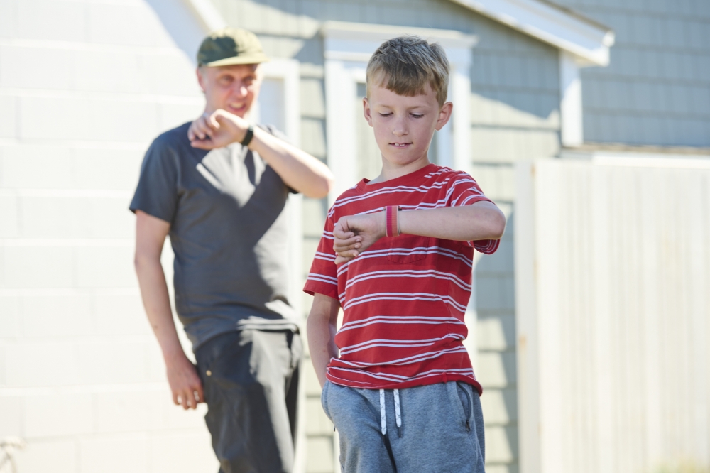 Felix Fangohr talks to his dad with his Apple Watch SE outside the family's rented Airbnb vacation home on Guemes Island, Wash. on Aug. 29, 2022. (Chona Kasinger/The New York Times)