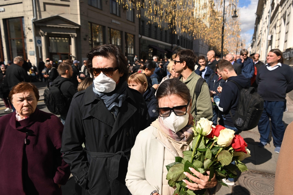 A woman holds flowers as she stands in line to attend a farewell ceremony for the last leader of the Soviet Union and winner of the Nobel Peace Prize in 1990, Mikhail Gorbachev is taking place in Moscow 