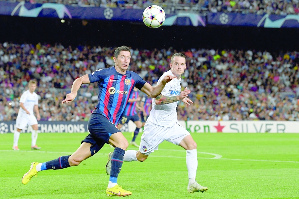 Barcelona's Polish forward Robert Lewandowski (L) fights for the ball with Viktoria Plzen's Czech midfielder Jan Sykora during the UEFA Champions League Group C first-leg football match between FC Barcelona and Viktoria Plzen, at the Camp Nou stadium in Barcelona on September 7, 2022. (Photo by Josep LAGO / AFP)