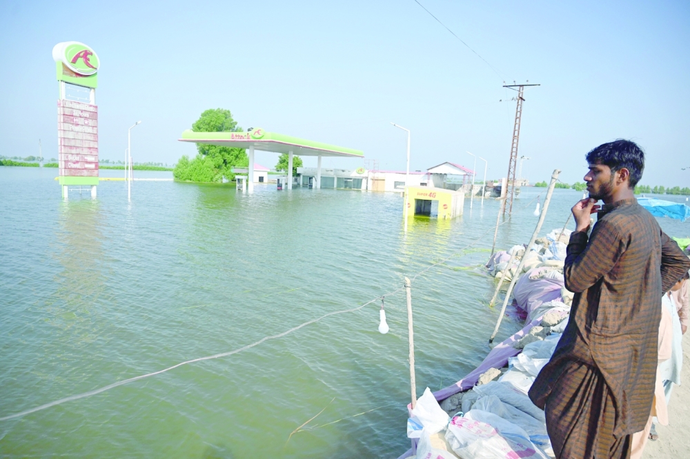 Flood-affected people gather by an embankment in Mehar city after heavy monsoon rains in Dadu district, Sindh province.  -- AFP
