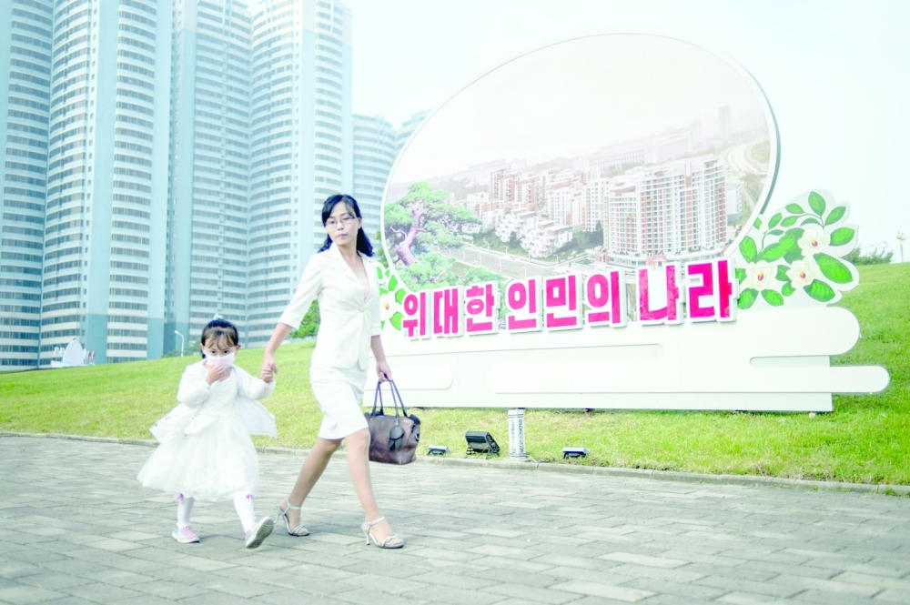A woman and a child walk on a street in Pyongyang as North Korea marks its 74th founding anniversary. -- AFP
