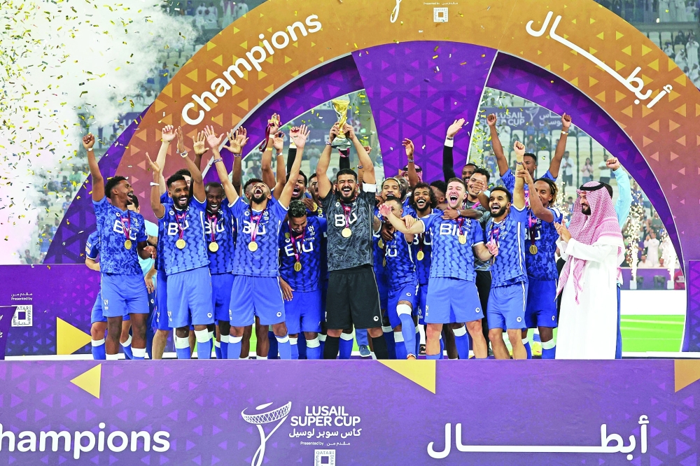 Hilal's players celebrate with the trophy after winning the Lusail Super Cup football match between Saudi Arabia's Al Hilal and Egypt's Zamalek at the Lusail Stadium on the outskirts of Qatar's capital Doha on September 9, 2022.  (Photo by Karim JAAFAR / AFP)