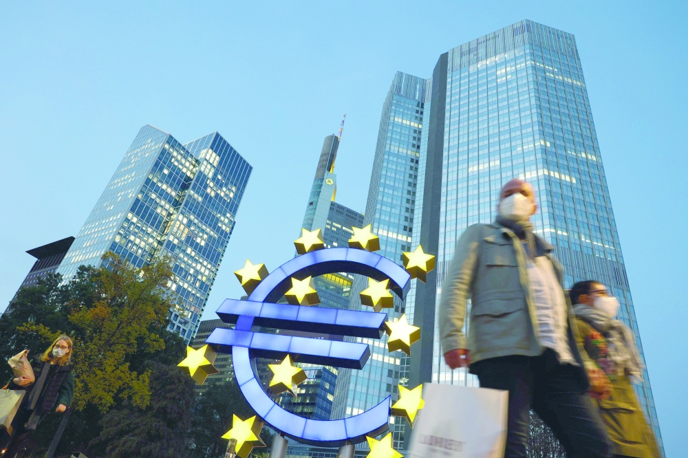 People walk in front of the euro sign at the former ECB headquarters in Frankfurt am Main, Germany. — AFP