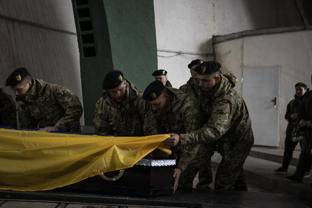 Ukrainian soldiers carry a casket containing the body of fellow soldier Ivan Hvozdev, who was killed in Mykolaiv, prior to his burial in Kyiv, Ukraine on Sept. 10, 2022. (Jim Huylebroek/The New York Times)