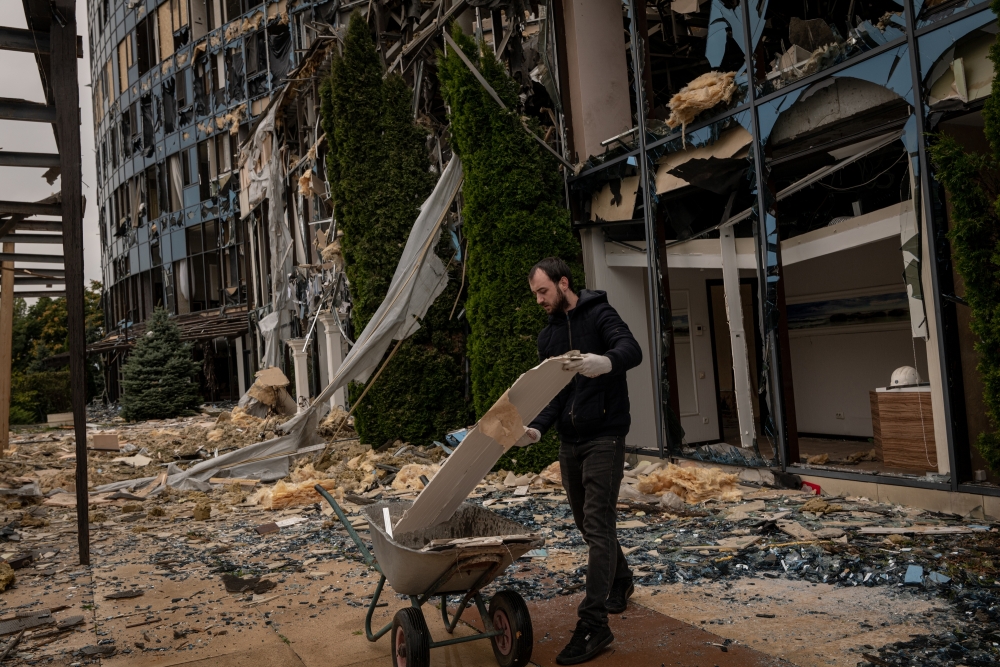 A volunteer cleans up debris at the Misto Entertainment Complex in Kharkiv, Ukraine, on Sunday, Sept. 11, 2022. (Nicole Tung/The New York Times)