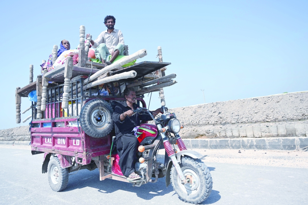 An internally displaced flood-affected family travels on a vehicle with their belongings in Mehar city after heavy monsoon rains in Dadu district, Sindh province. - AFP

