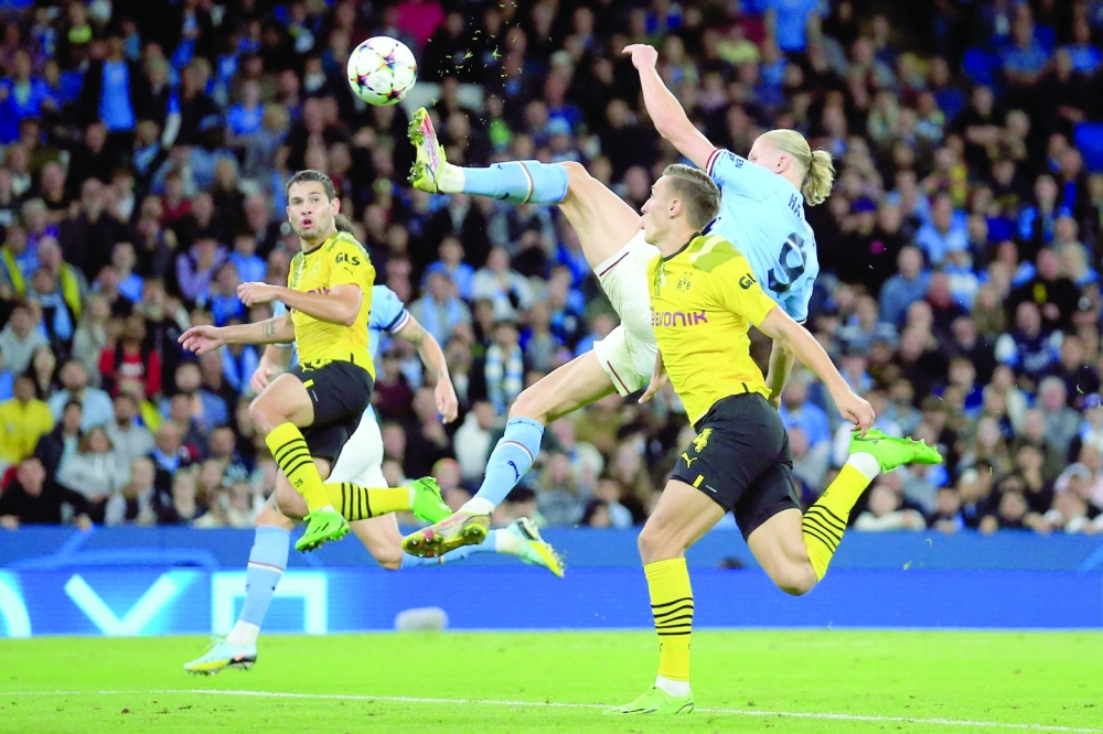 Manchester City's Norwegian striker Erling Haaland (C) shoots to score his team's second goal during the UEFA Champions League group G football match between England's Manchester City and Germany's Borussia Dortmund at the Etihad Stadium in Manchester on September 14, 2022. (Photo by Lindsey Parnaby / AFP)

