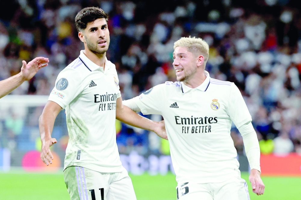 Real Madrid's Spanish midfielder Marco Asensio (L) celebrates with Real Madrid's Uruguayan midfielder Federico Valverde after scoring his team's second goal during the UEFA Champions League, Group F, first leg football match between Real Madrid and RB Leipzig at the Santiago Bernabeu stadium in Madrid on September 14, 2022.  (Photo by THOMAS COEX / AFP)

