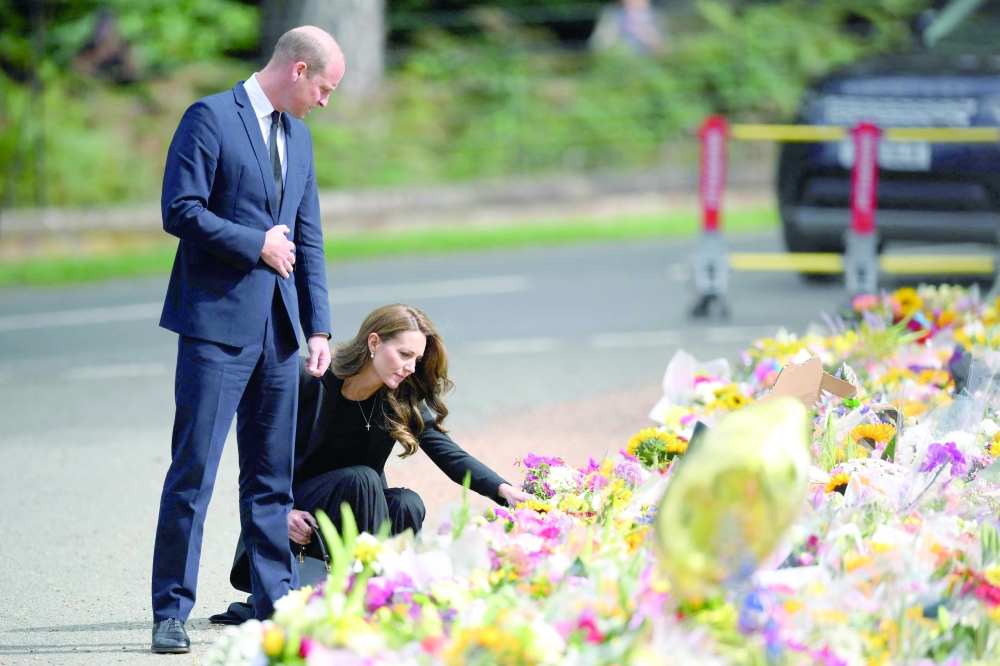 Prince William, Prince of Wales, and Catherine, Princess of Wales look at floral tributes outside Norwich Gate on the Sandringham Estate in Sandringham, eastern England, on Thursday following the death of Queen Elizabeth II.  — AFP Reports on p3