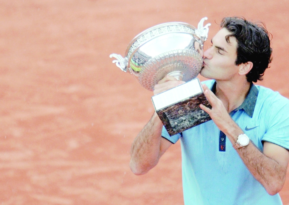 (FILES) In this file photo taken on June 7, 2009 Swiss Roger Federer kisses the trophy after winning against Swedish player Robin Soderling during their French Open tennis men's final match at Roland Garros Stadium in Paris. Swiss tennis legend Roger Federer is to retire after next week's Laver Cup, he said on September 15, 2022. (Photo by Lionel BONAVENTURE / AFP)

