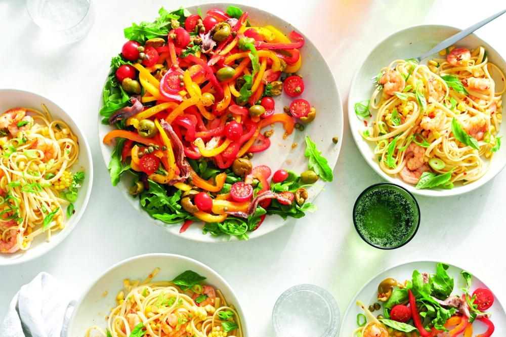 Bell pepper salad with capers and olives and shrimp pasta with corn and basil in New York, Aug. 31, 2022. Food styled by Greg Lofts. (David Malosh/The New York Times)