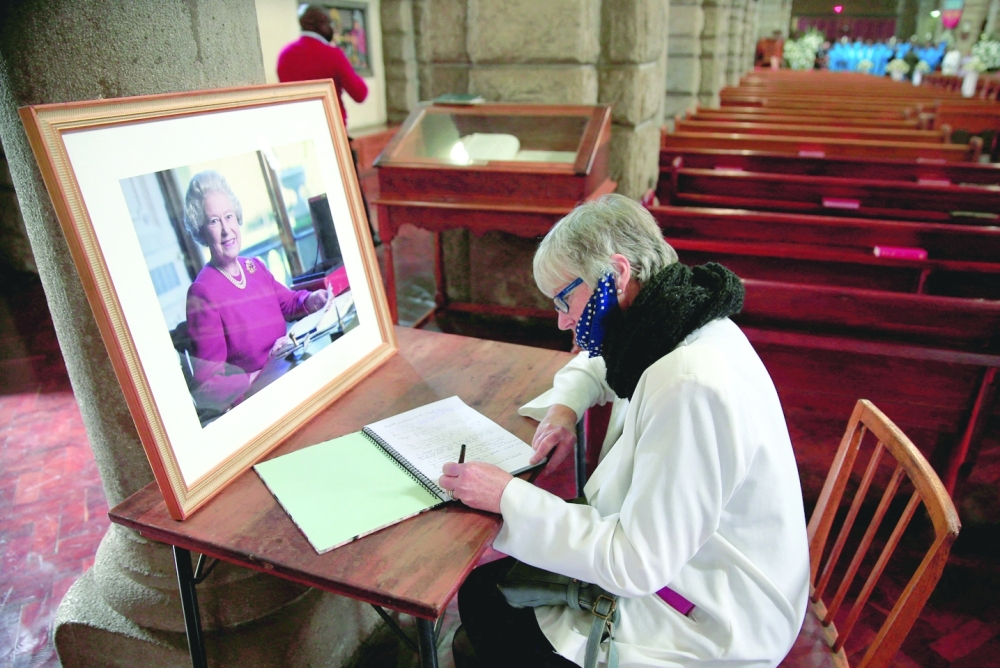 Zimbabwean Sue Arkell signs a book of condolences for the late Queen Elizabeth II in Harare. -- Reuters
