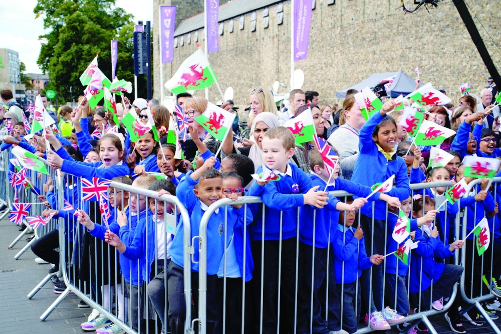 Schoolchildren wait for King Charles to arrive at Cardiff Castle in Wales. -- Reuters