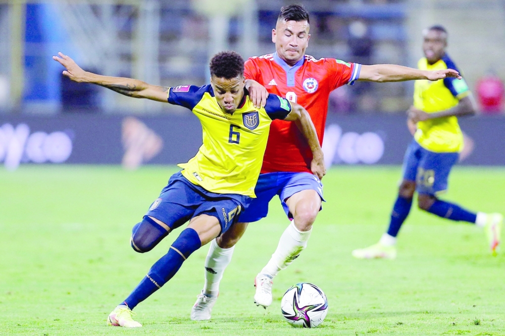 (FILES) In this file photo taken on November 16, 2021, Ecuador's Byron Castillo (L) and Chile's Jean Meneses vie for the ball during their South American qualification football match for the Fifa World Cup Qatar 2022 at the San Carlos de Apoquindo stadium in Santiago. The information published on September 12, 2022, by an English newspaper that footballer Byron Castillo would have admitted to being Colombian and not Ecuadorean as presented by the local football federation, "further consolidates our complaint," Pablo Milad, president of the Chilean Professional Football Association said. Earlier this year Chile, which failed to qualify for the World Cup, had lodged a complaint with FIFA against Ecuador, which did make the cut, for allegedly fielding an ineligible player in qualifying matches, but after disciplinary proceedings FIFA closed the case. (Photo by Marcelo HERNANDEZ / POOL / AFP)