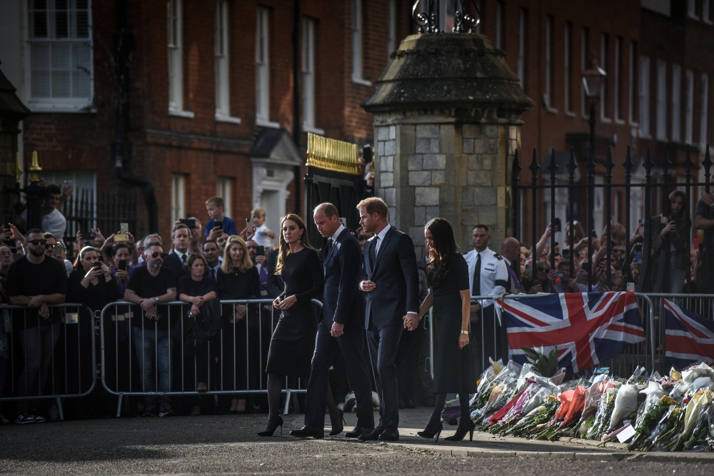 Prince William, center left, and his wife, Catherine, are unexpectedly joined by Prince Harry and his wife, Meghan, in a 40-minute walk to inspect tributes and meet the crowds outside Windsor Castle in Windsor, England, on Sunday, Sept. 11, 2022.  (Mary Turner/The New York Times)