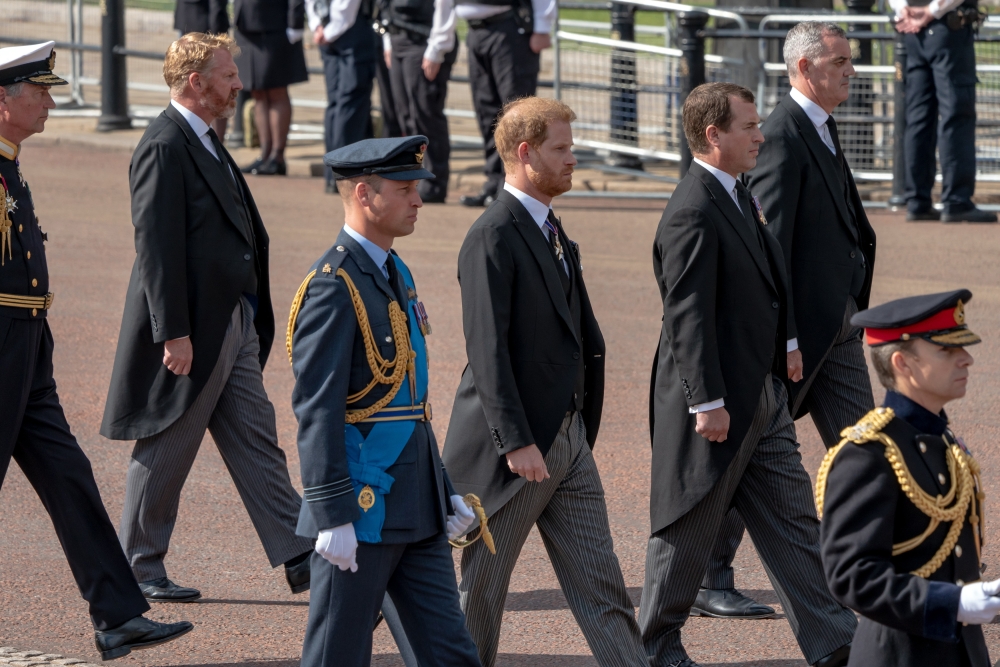 Prince William, center left, and his brother Prince Harry, center right, walk behind the coffin of their grandmother, Queen Elizabeth II, in London on Wednesday, Sept. 14, 2022.  (Andrew Testa/The New York Times)