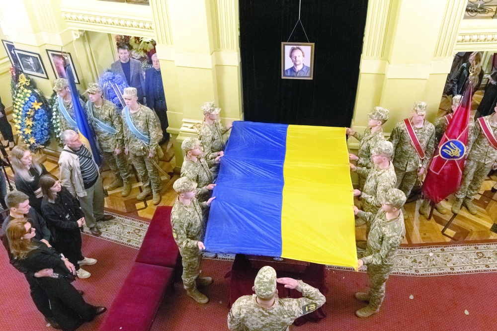 Members of Honour Guard hold a national flag over a coffin with the body of Ukrainian serviceman and famous ballet dancer Oleksandr Shapoval, who was recently killed in a fight against Russian troops in Donetsk region, amid Russia's attack on Ukraine, during a funeral ceremony at the National Opera of Ukraine in Kyiv. - Reuters
