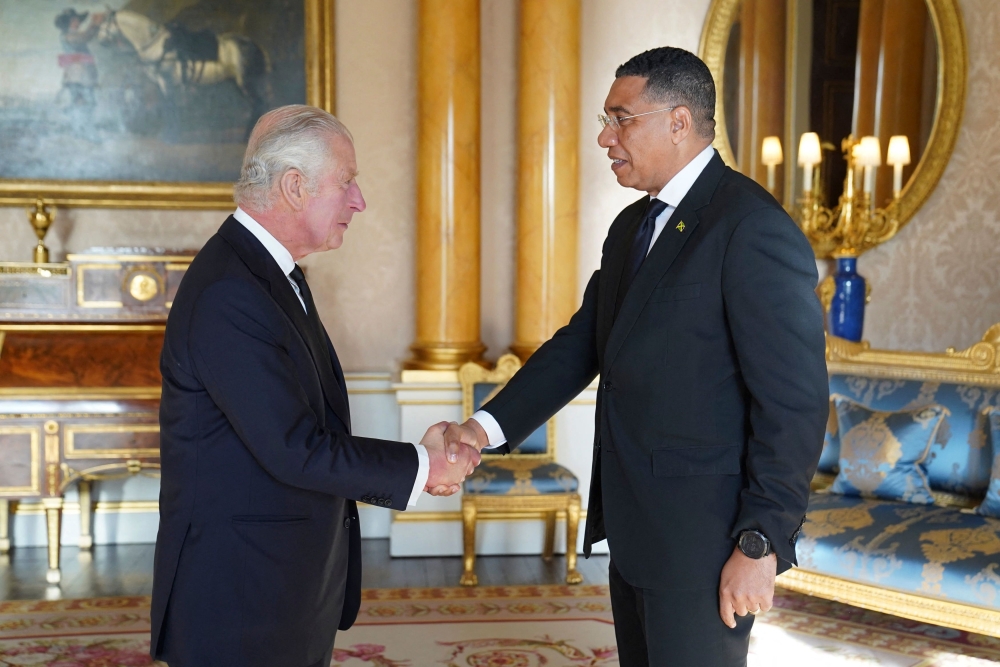 Britain's King Charles III (L) shakes hands with Andrew Holness (R), Prime Minister of Jamaica