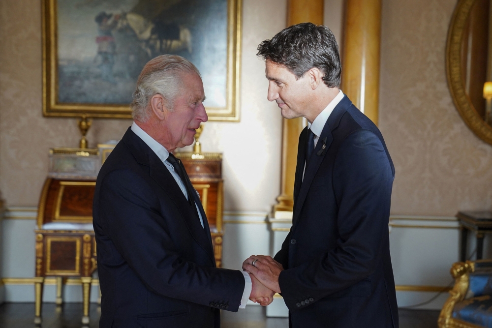 Britain's King Charles III (L) shakes hands with Canadian Prime Minister Justin Trudeau