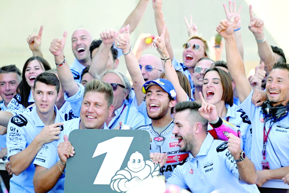 Ducati Gresini Italian rider Enea Bastianini (C) celebrates with his team staff members after winning the Moto Grand Prix GP of Aragon at the Motorland circuit in Alcaniz on September 18, 2022.  (Photo by Pierre-Philippe MARCOU / AFP)

