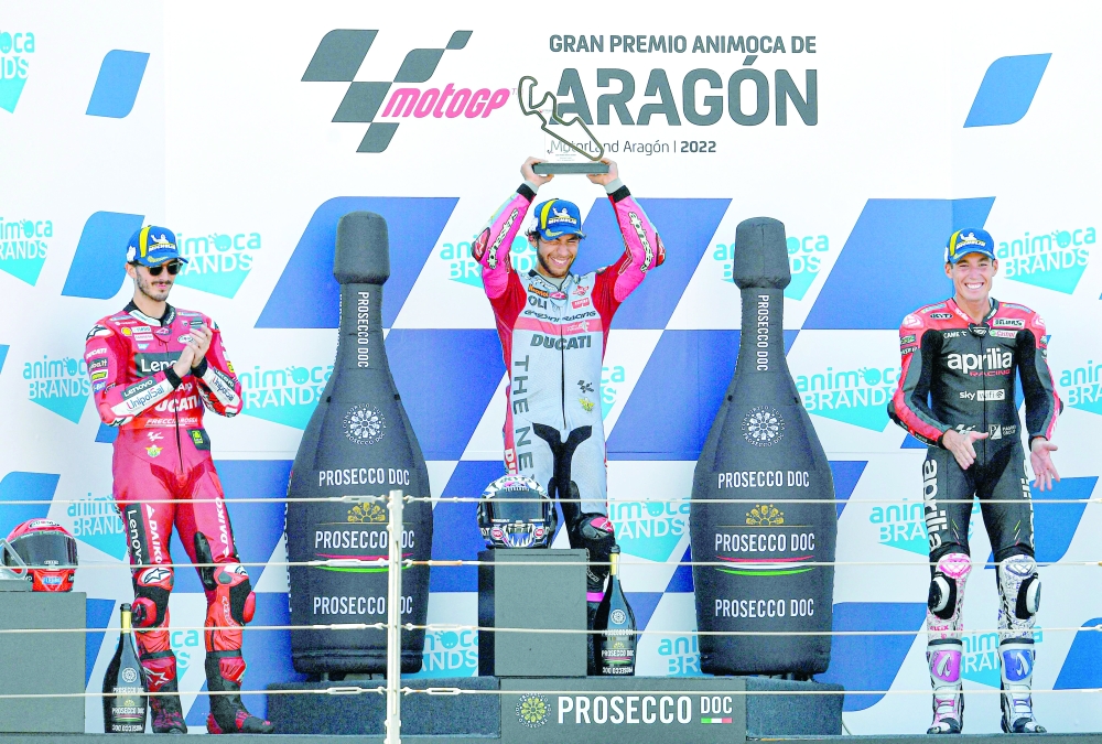 First placed Ducati Gresini Italian rider Enea Bastianini (C), second placed Ducati Italian rider Francesco Bagnaia and third placed Aprilia Spanish rider Aleix Espargaro celebrate on the podium after the Moto Grand Prix GP of Aragon at the Motorland circuit in Alcaniz on September 18, 2022.  (Photo by Pau BARRENA / AFP)

