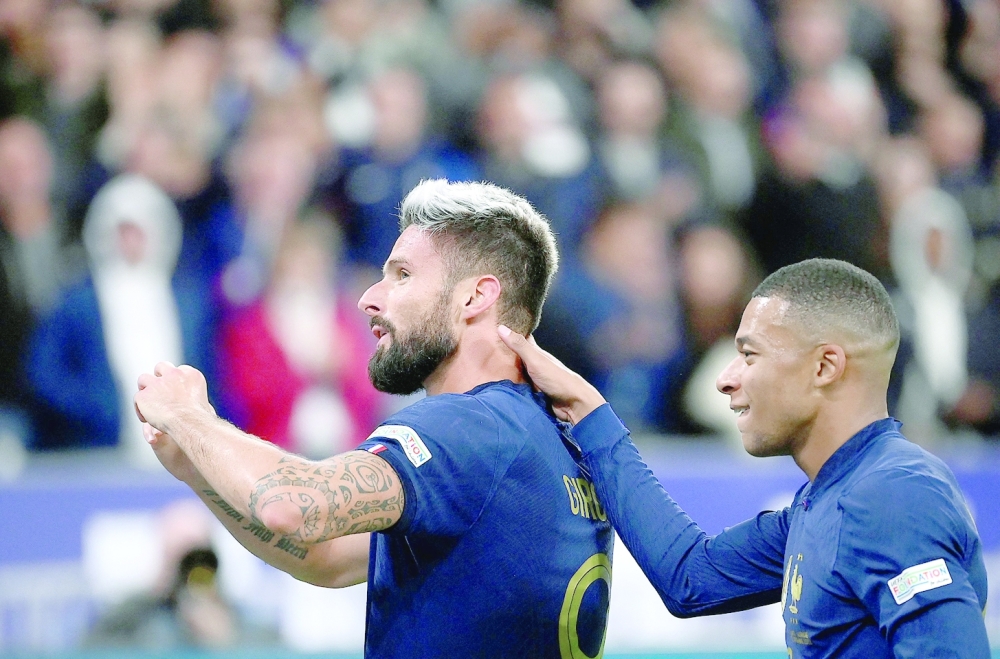 France's forward Olivier Giroud (L) is congratuled by France's forward Kylian Mbappe after scoring a goal during the UEFA Nations League, League A Group 1 football match between France and Austria at Stade de France in Saint-Denis, north of Paris, on September 22, 2022. (Photo by FRANCK FIFE / AFP)

