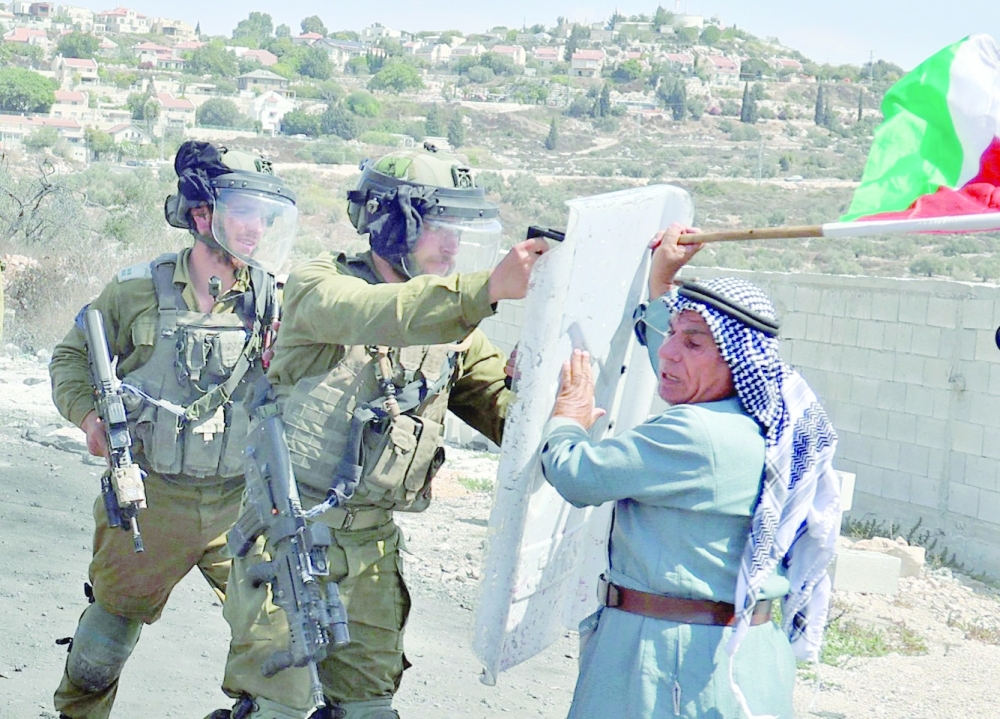 A Palestinian demonstrator confronts Israeli security forces following a protest against the expropriation of Palestinian land by Israel in the village of Kfar Qaddum in the occupied West Bank near the Jewish settlement of Kedumim on Friday. -- AFP