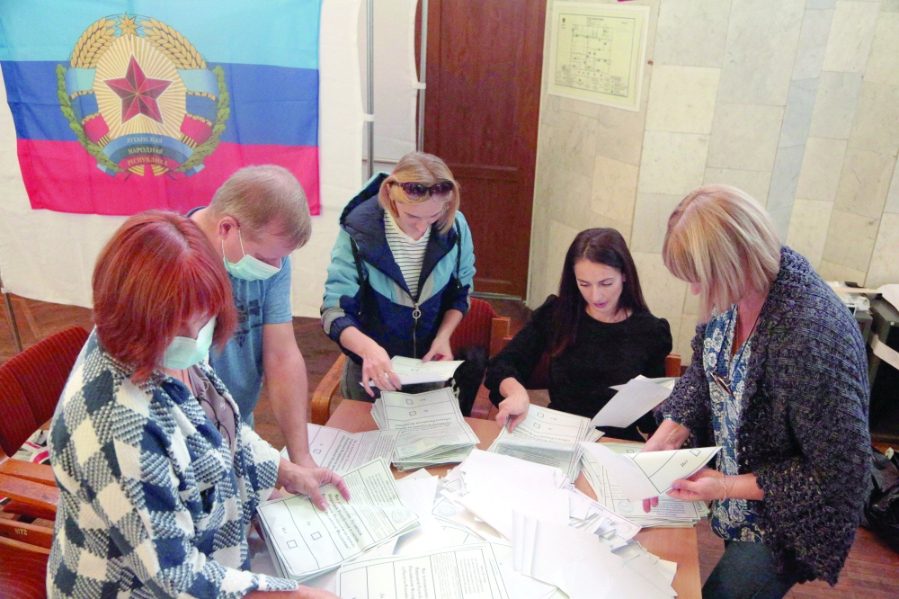 Election commission members count votes of refugees from Russian-held regions of Ukraine for a referendum at a polling station in Simferopol, Crimea. - AFP