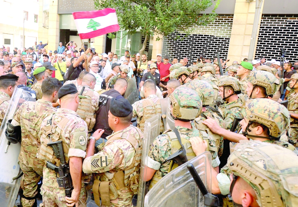 Lebanese army soldiers clash with retired military personnel as they try to break into the parliament in Beirut during a session to approve the 2022 budget. - AFP


