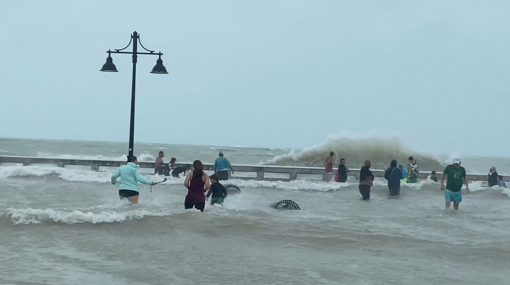 People gather at Key West pier as Hurricane Ian approaches, in Key West, Florida, U.S., September 27, 2022, in this screen grab taken from a social media video. Gwen Filosa/via 