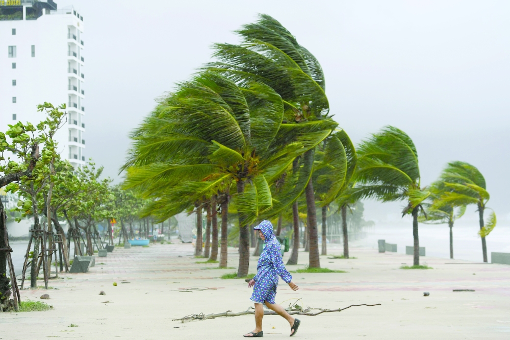 A man walks along the beach following the passage of typhoon Noru in Danang. -  AFP