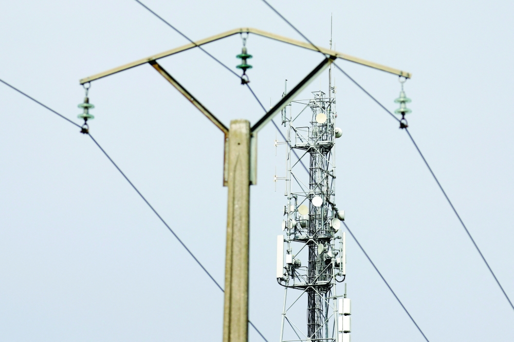 A mobile-phone relay mast is seen behind an electrical pylon in Tilloy-les-Cambrai, France. -- Reuters