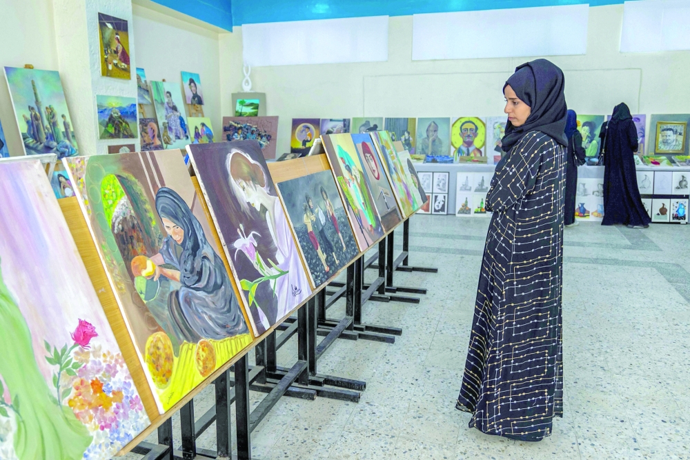 A woman views paintings at a graduation exhibition for Fine Arts students from Taez University, in Taez.— AFP