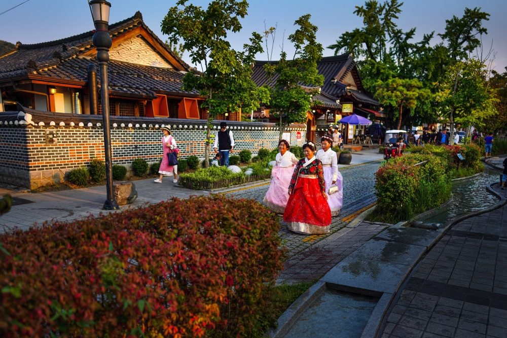 Women in hanbok, traditional Korean dresses, walk through the streets of Jeonju, South Korea, Sept. 29, 2019. (Chang W. Lee/The New York Times)