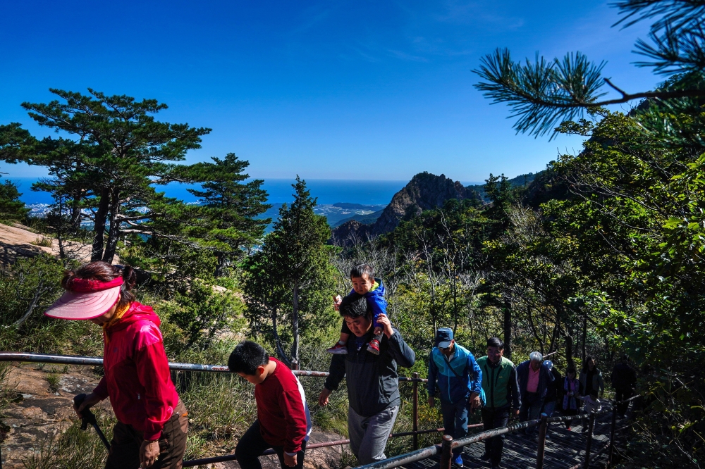 Visitors hike from a cable car to Gwongeum Fortress inside Seoraksan National Park in South Korea, Oct. 9, 2019. (Chang W. Lee/The New York Times)