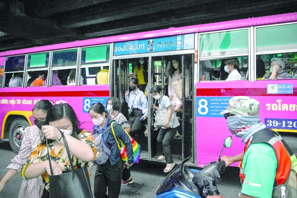 Passengers alight a No 8 bus in Bangkok. -- AFP