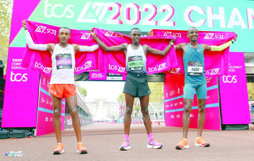Athletics - London Marathon - London, Britain - October 2, 2022 Kenya's Amos Kipruto celebrates after winning the men's elite race alongside second place Ethiopia's Leul Gebresilase and third place Belgium's Bashir Abdi Action Images via Reuters/Andrew Boyers
