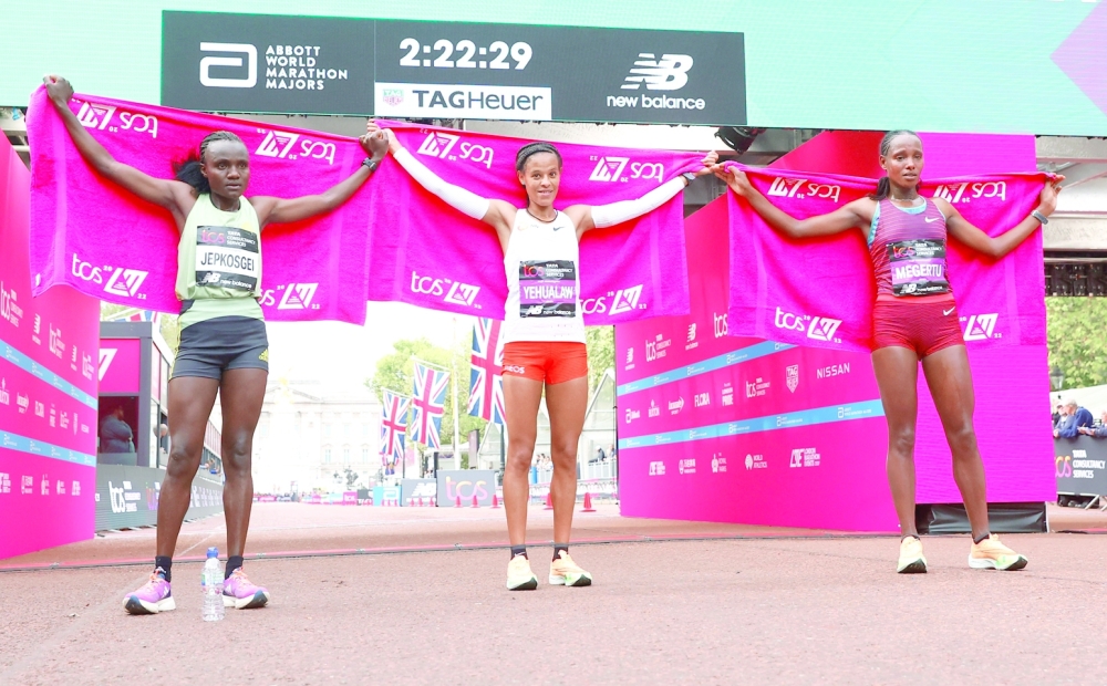 Athletics - London Marathon - London, Britain - October 2, 2022 Ethiopia's Yalemzerf Yehualaw celebrates after winning the women's elite race alongside second place Kenya's Joyciline Jepkosgei and third place Ethiopia's Alemu Megertu Action Images via Reuters/Andrew Boyers
