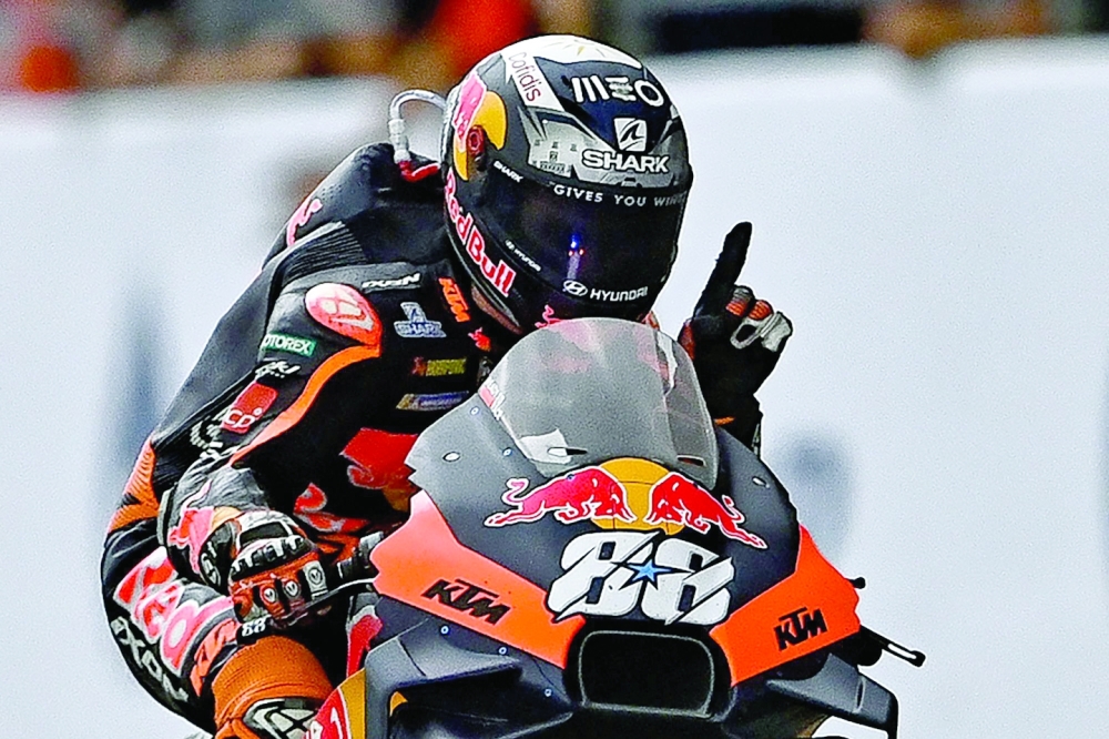 TOPSHOT - Red Bull KTM Factory Racing's Portuguese rider Miguel Oliveira celebrates winning the MotoGP Thailand Grand Prix at the Buriram International Circuit in Buriram on October 2, 2022.  (Photo by Manan VATSYAYANA / AFP)

