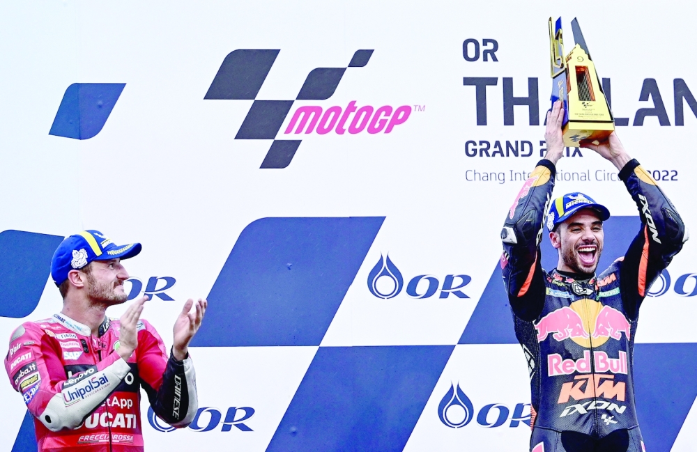 TOPSHOT - Winner Red Bull KTM Factory Racing's Portuguese rider Miguel Oliveira (R) celebrates next to second-placed Ducati Lenovo's Australian rider Jack Miller (L) during the podium ceremony after the MotoGP Thailand Grand Prix at the Buriram International Circuit in Buriram on October 2, 2022.
  (Photo by MANAN VATSYAYANA / AFP)

