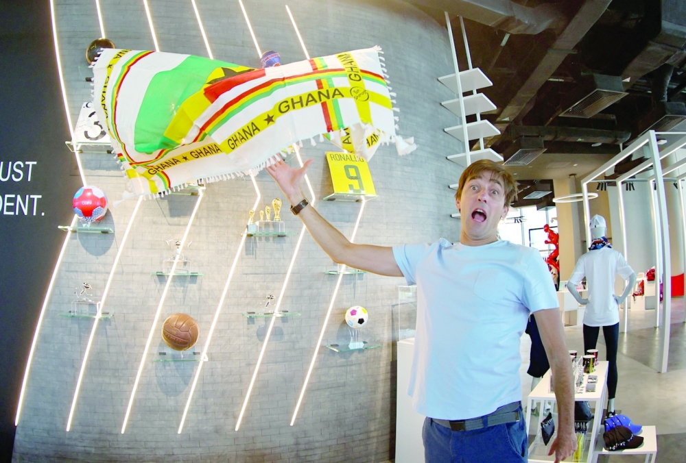 Didier Grande, tosses in the air one of the fan shemagh scarves, also known as ghutra or keffiyeh, that he designed with his business partner in the national colours of the 32 countries taking part in the World Cup. — AFP