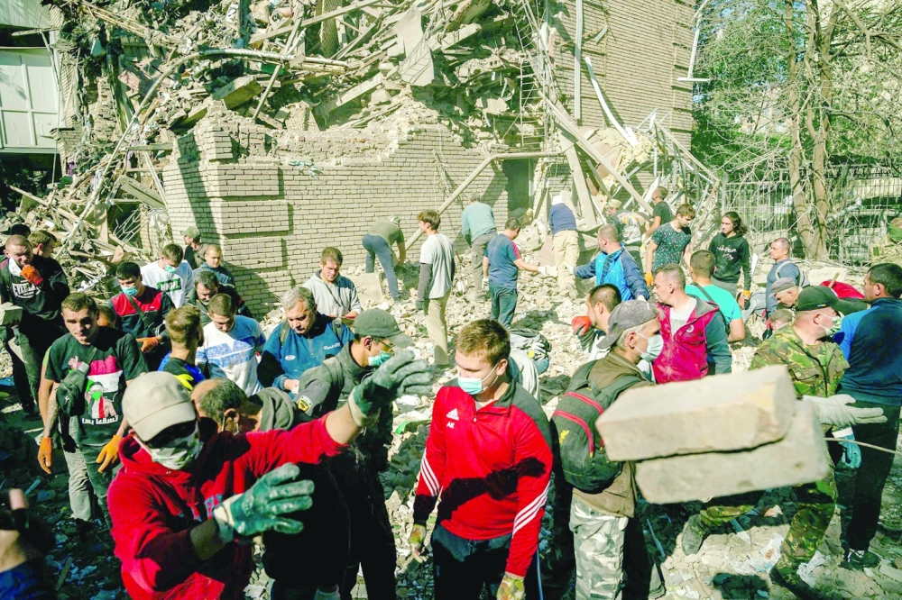 Volunteers remove the rubbles of a building looking for survivors after a strike in Zaporizhzhia on Thursday, amid the Russian invasion of Ukraine. -- AFP