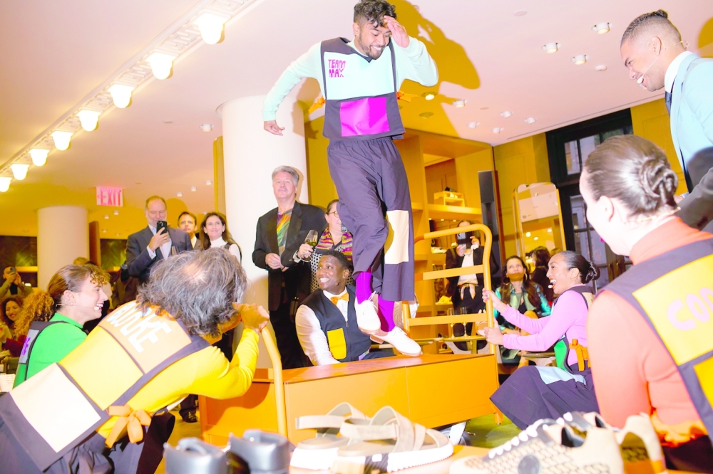 A performer tap-dances on props made to resemble the classic orange Herm