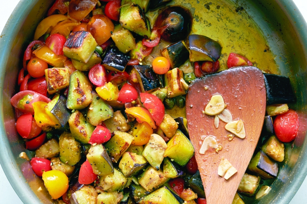 Chopped eggplant, cherry tomatoes and capers are cooked together for a pasta dish, in New York, Aug. 4, 2022. Food styled by Simon Andrews. (David Malosh/The New York Times)